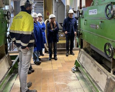 Elever inne i et fabrikk-anlegg.