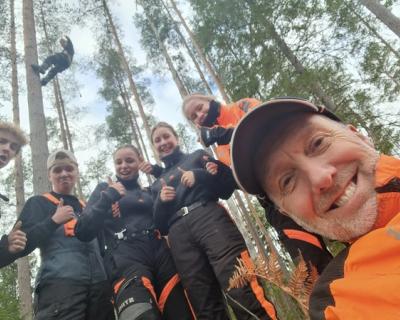 Lærer og elever tar selfiebilde fra skogen. 