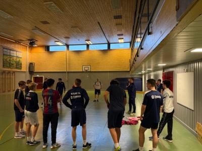 Elever med gymklær på instrueres i en gymsal.