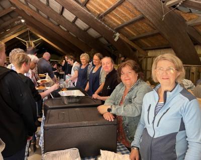 Kjøkkenpersonell serverer mat på låvefesten.