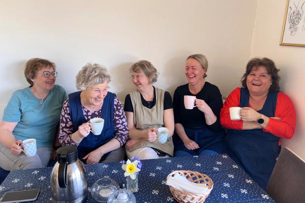 Fem blide damer i kjøkkenkroken