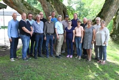 Kvinner og menn ved et tre i parken en sommerdag.