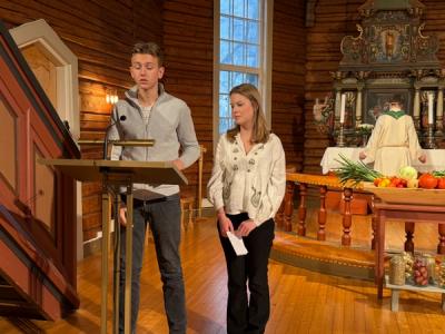 To elever står ved en lesepult i kirken. 