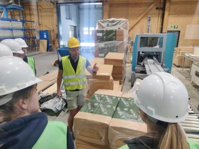 I et fabrikkområde hvor en arbeider informerer elever om produkter som lages, her isolasjonsmatter av trefiber.