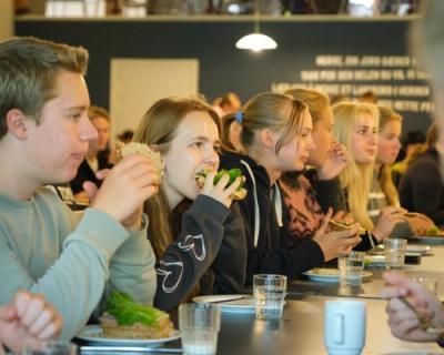 Elever sitter i matsalen og spiser