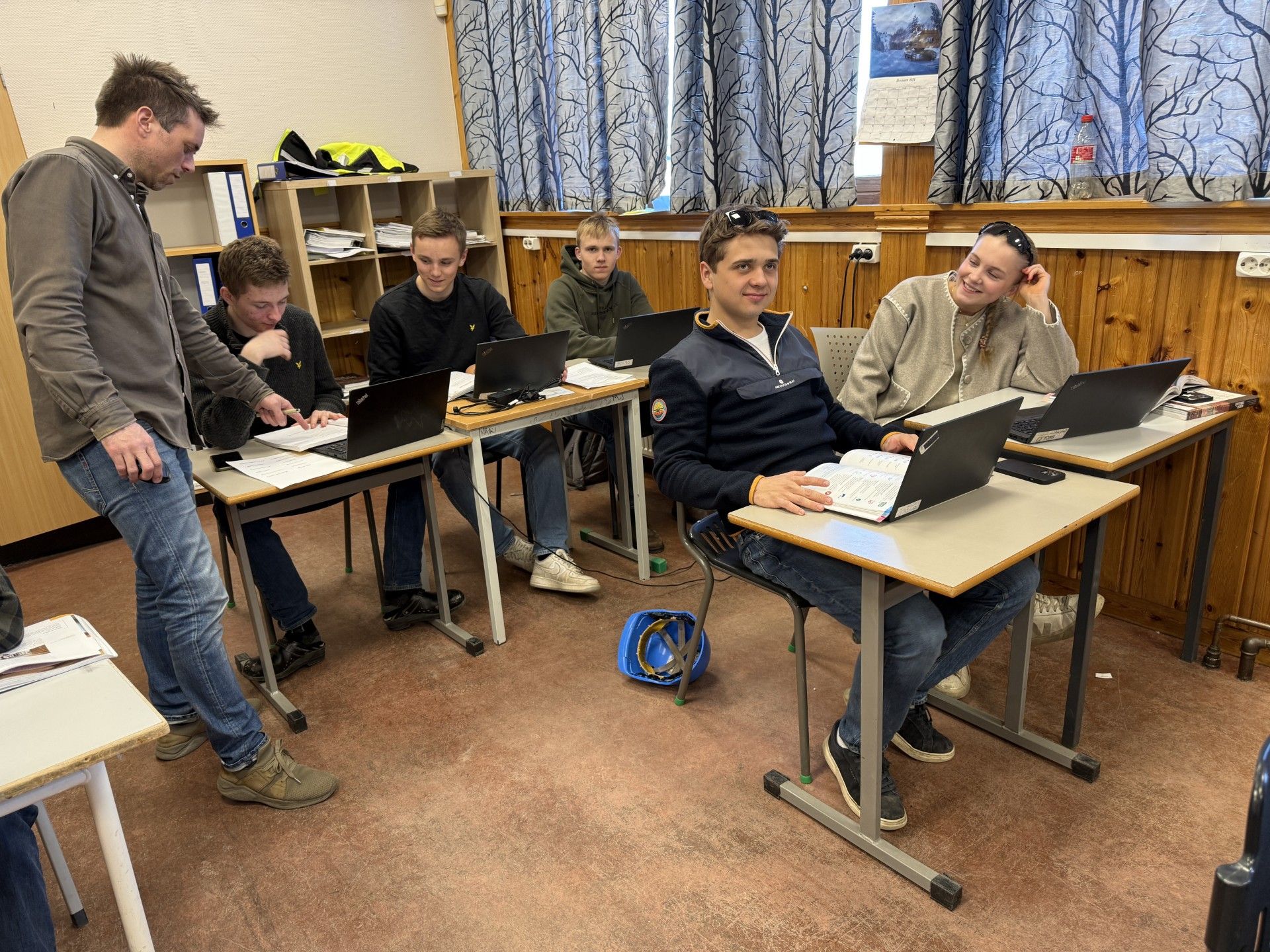 Elever jobber med oppgaver i et klasserom.