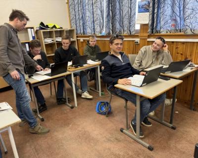 Elever jobber med oppgaver i et klasserom.