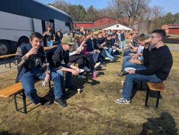 Elever sitter ute på benker og spiser