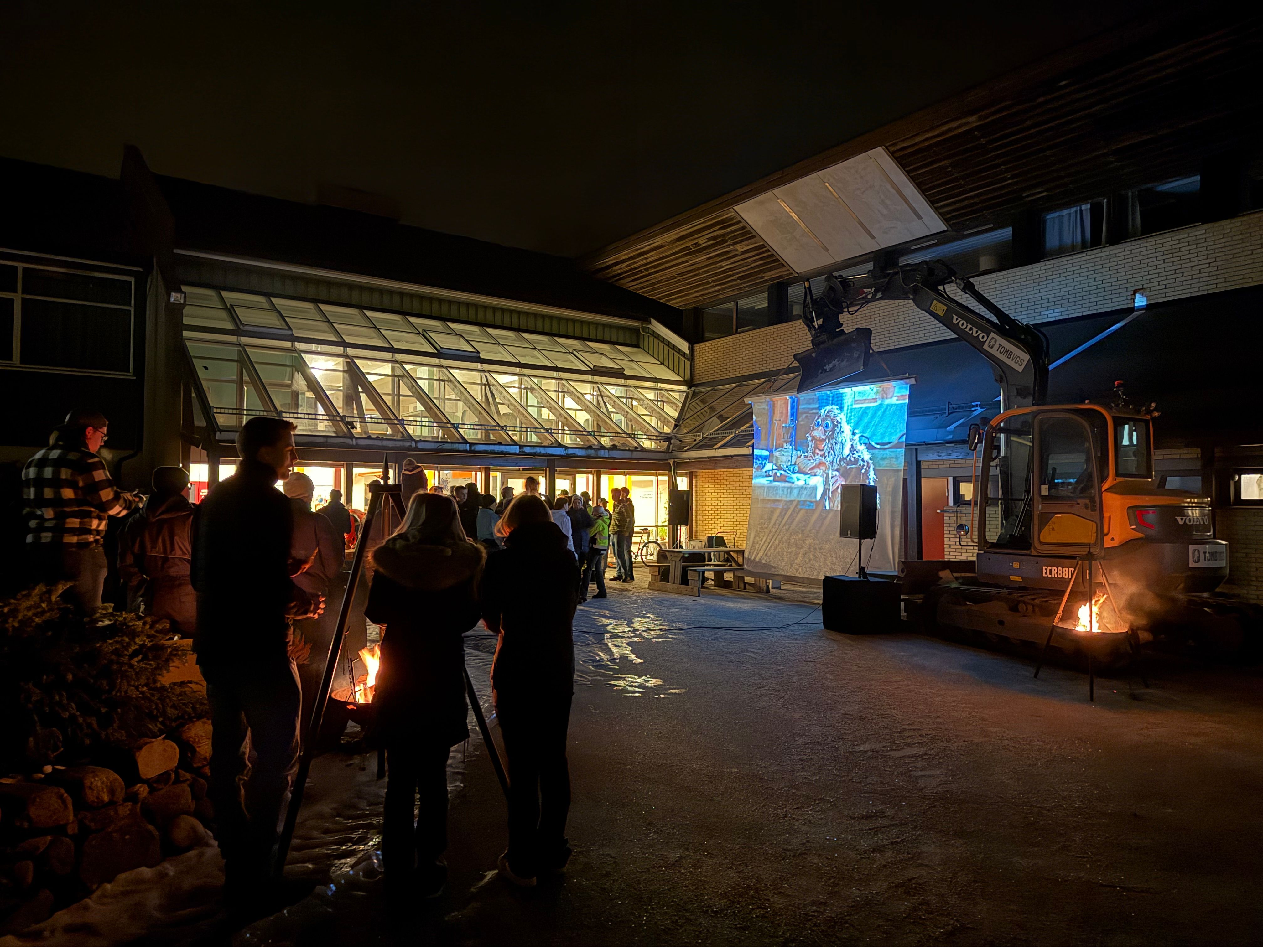 Utekino i mørket. Mange elever er samlet.