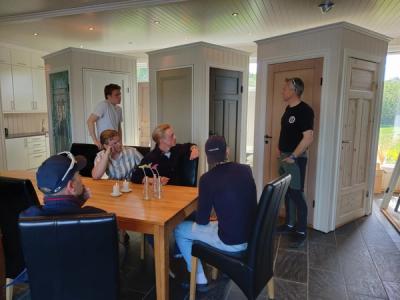 Utstillingslokale med ulike dørtyper. Informasjon gis til elever som sitter ved et bord.
