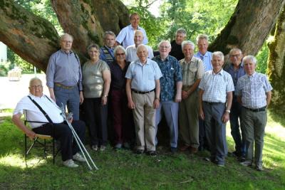 Kvinner og menn ved et tre i parken en sommerdag.