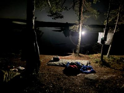 Soveposer bredt ut over en overnattingsplass. Mørket har senket seg.