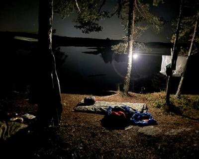 Soveposer bredt ut over en overnattingsplass. Mørket har senket seg.