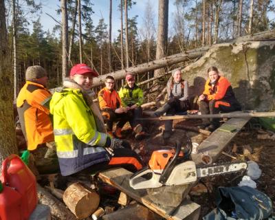 Elevgruppe sitter samlet i skogen.