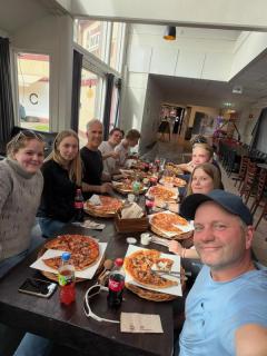 Elever spiser pizza ved et langbord.