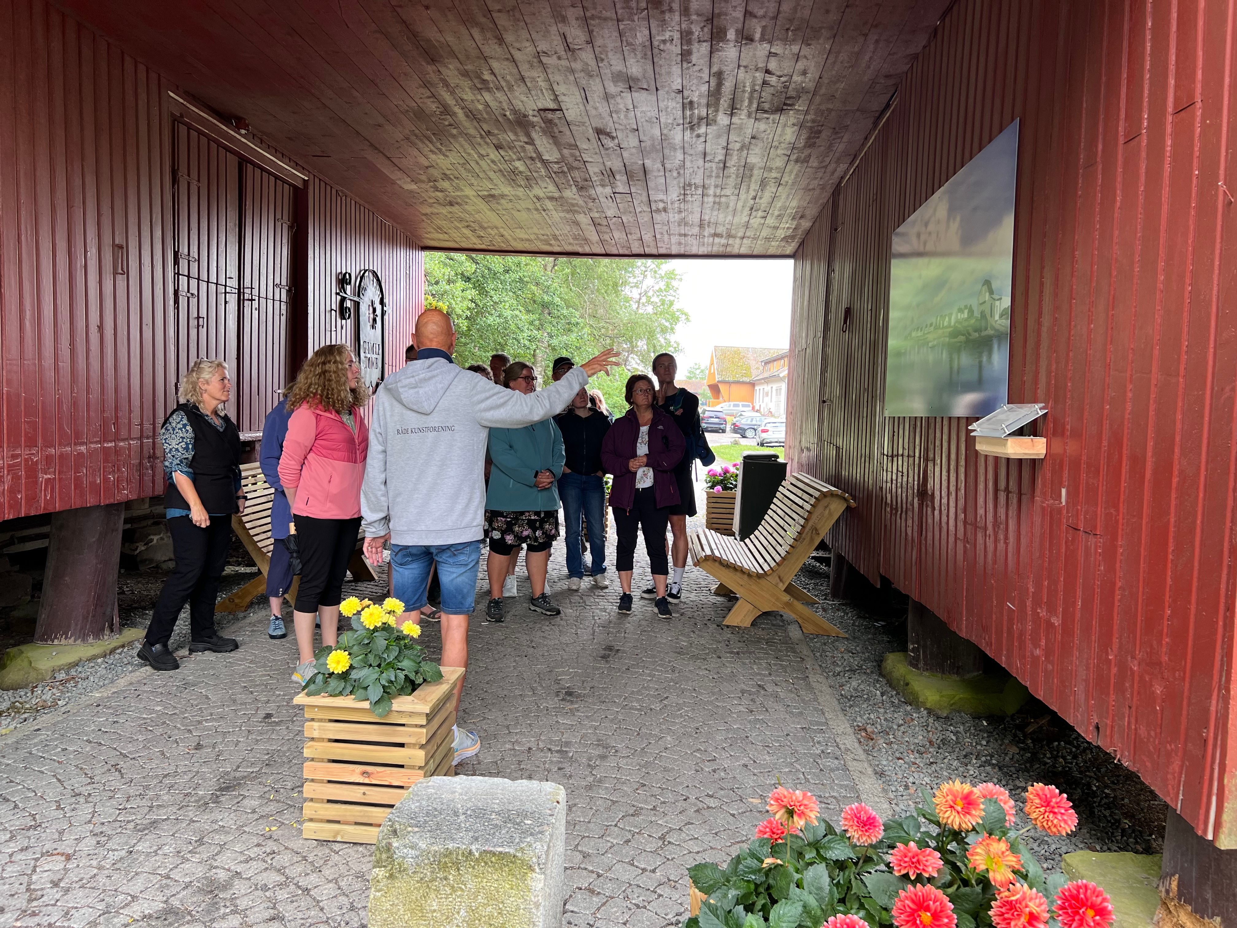 Mennesker samlet rundt bildet "Saltholmen som henger på en vegg.