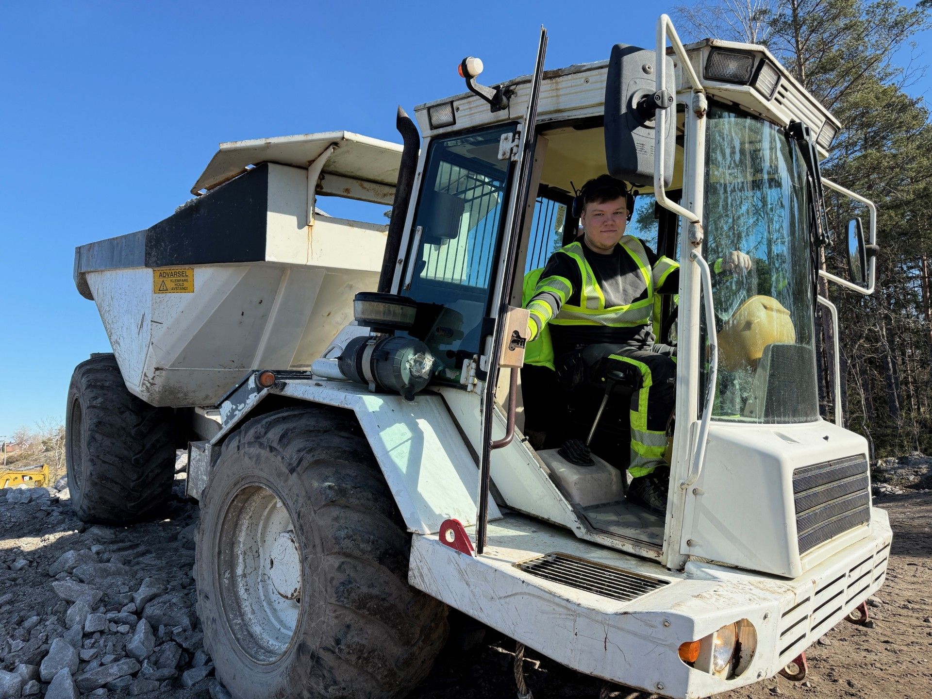 Elev sitter inne i en dumper
