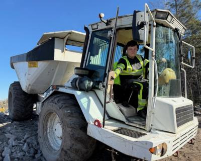 Elev sitter inne i en dumper