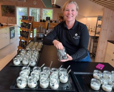 Dame som serverer havregrøt i porsjonsglass.