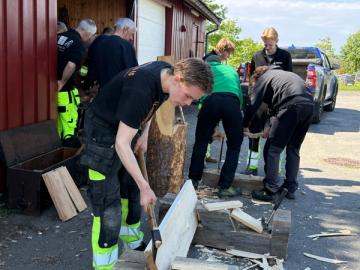 Elev tynner en planke med øks