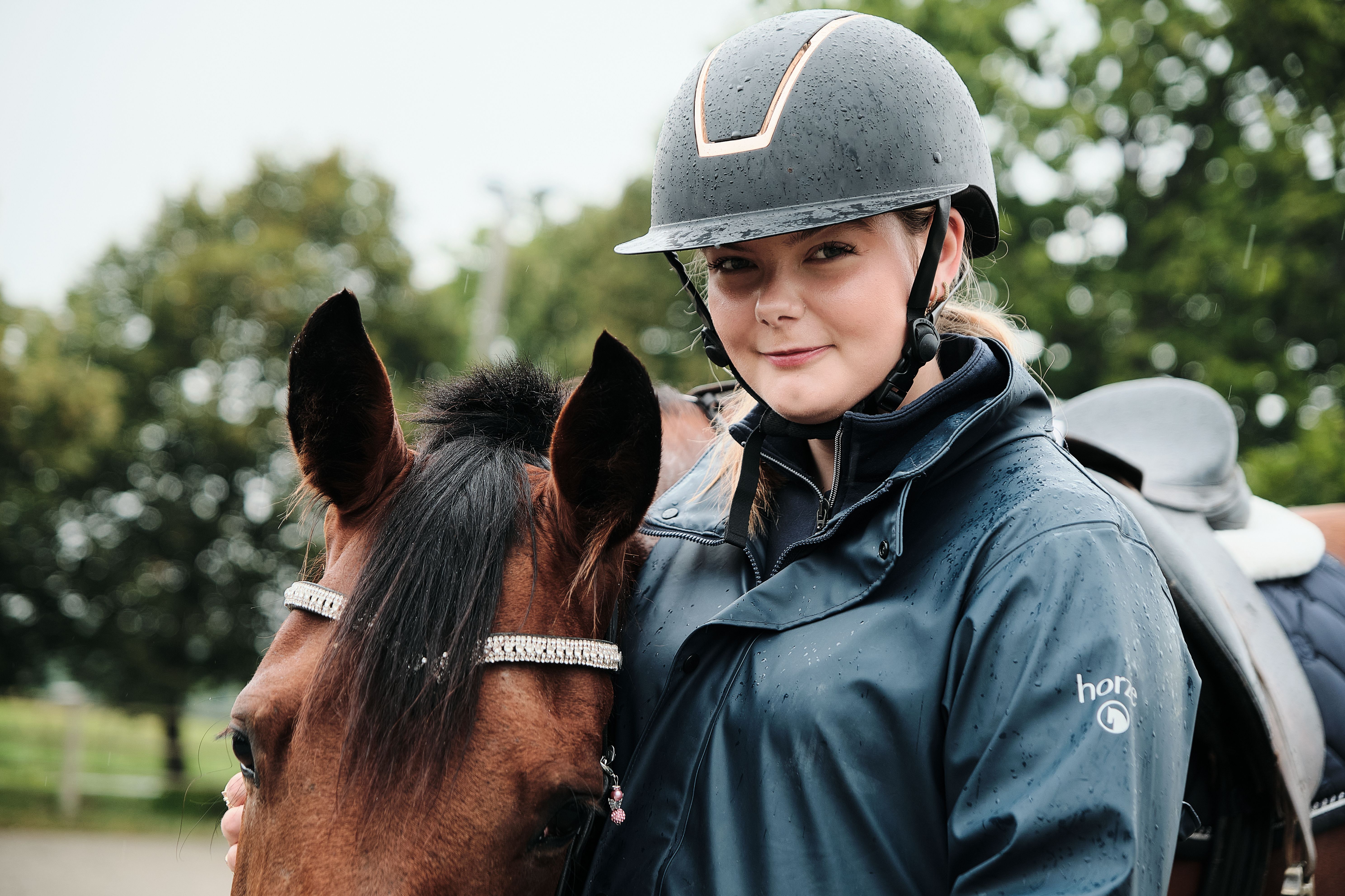 To elever rir hver sin hest på ridebane.