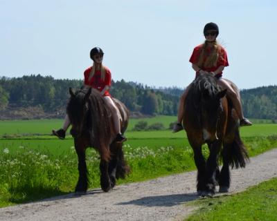 Elever som rir på grusvei