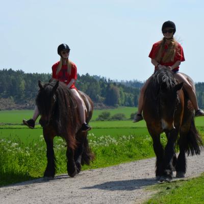 To jenter på tur med hestene sine. 