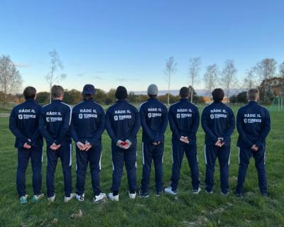 Åtte gutter poserer med ryggen til camera, nye drakter.