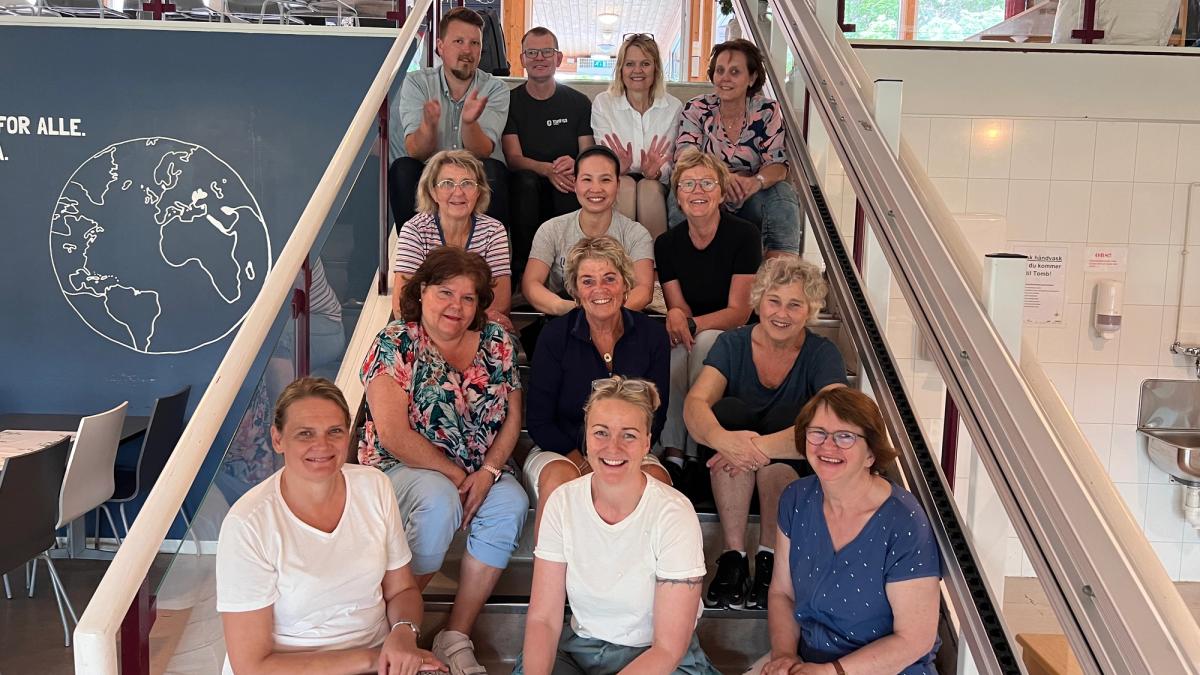 13 personer sitter i trappa.