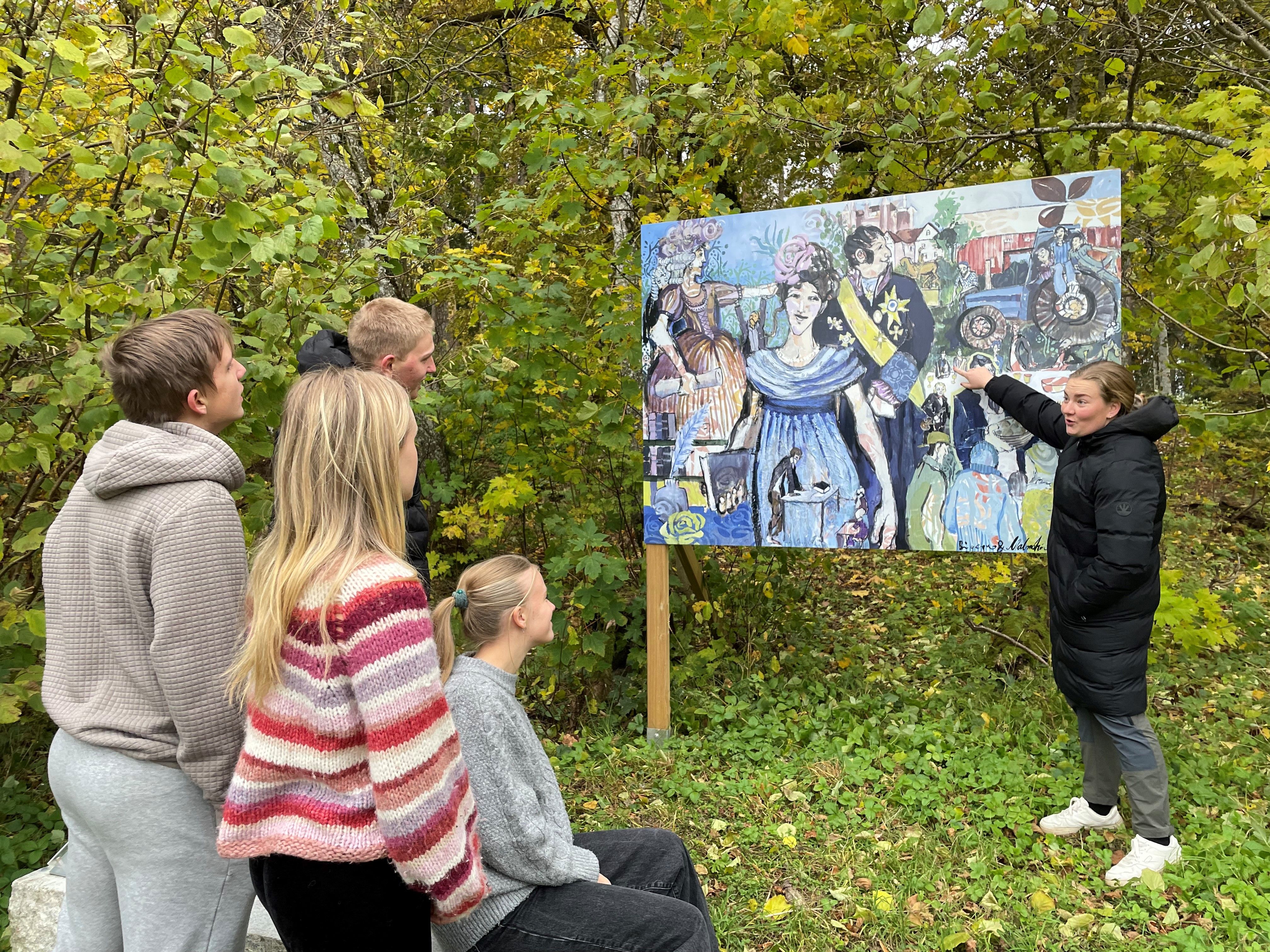 Elever blir forklart om et bilde som er utplassert i kunsstien.