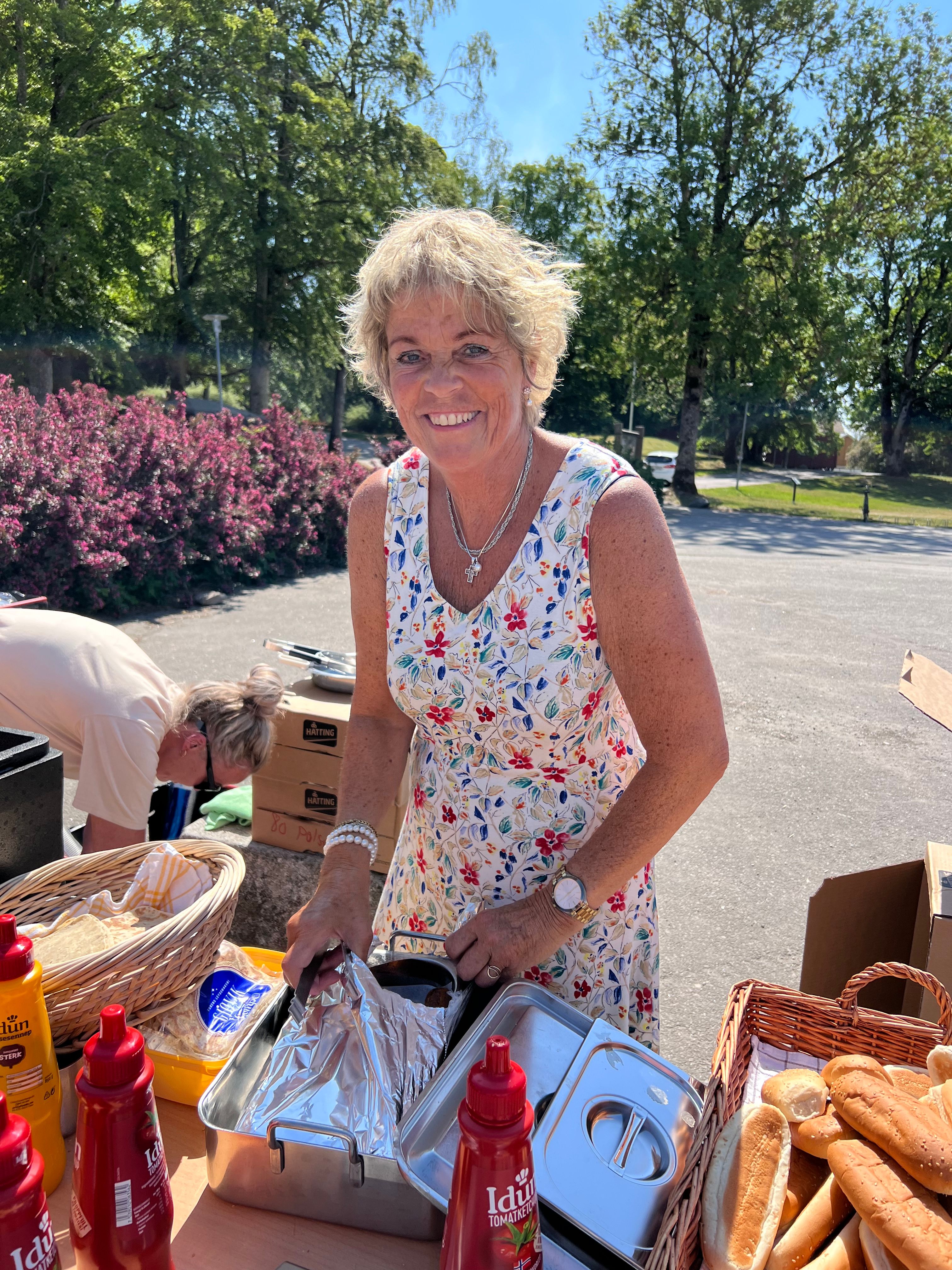 Smilende dame som serverer mat. 