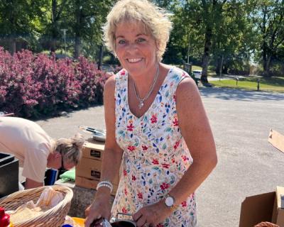 Smilende dame som serverer mat.