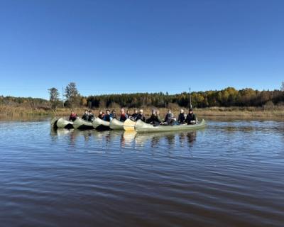 Elever sitter i kanoer.