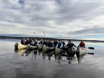 Elever i kanoer på stille vann.