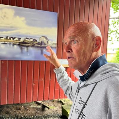 Leder i Kunstforeningen orienterer om bildet "Saltholmen" som henger på en vegg.