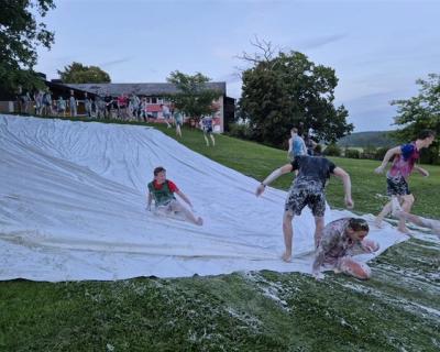 Elever sklir på presenning full av såpe