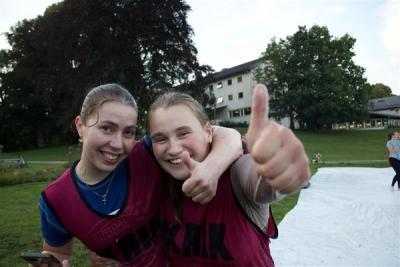 To smilende ungdommer i forkant av såpeskila i parken