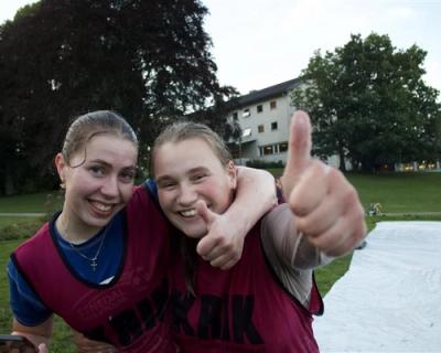 To smilende ungdommer i forkant av såpeskila i parken