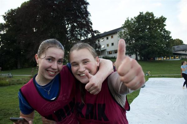 To smilende elevjenter foran en såpesklie i parken