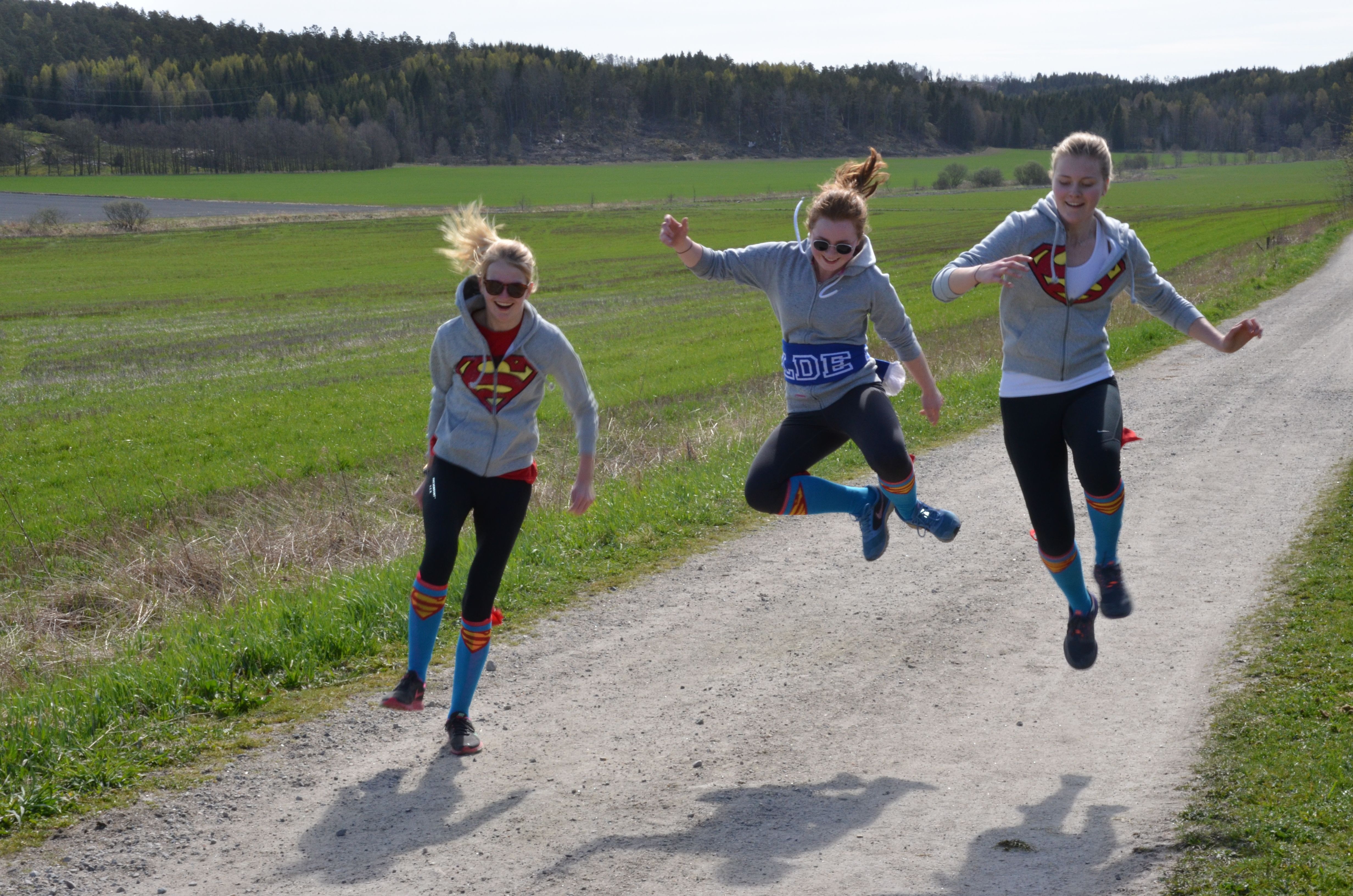 Elever som hopper av glede på en grusvei.