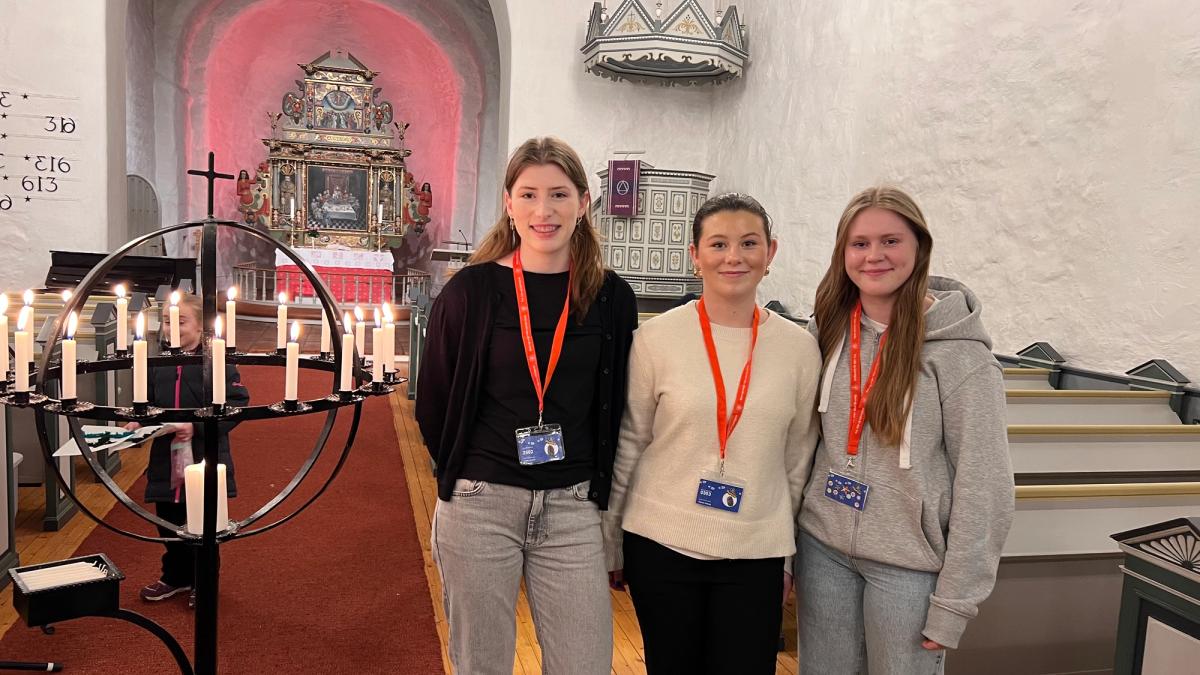 Tre jenter i Råde Kirke, med lysglobe bak