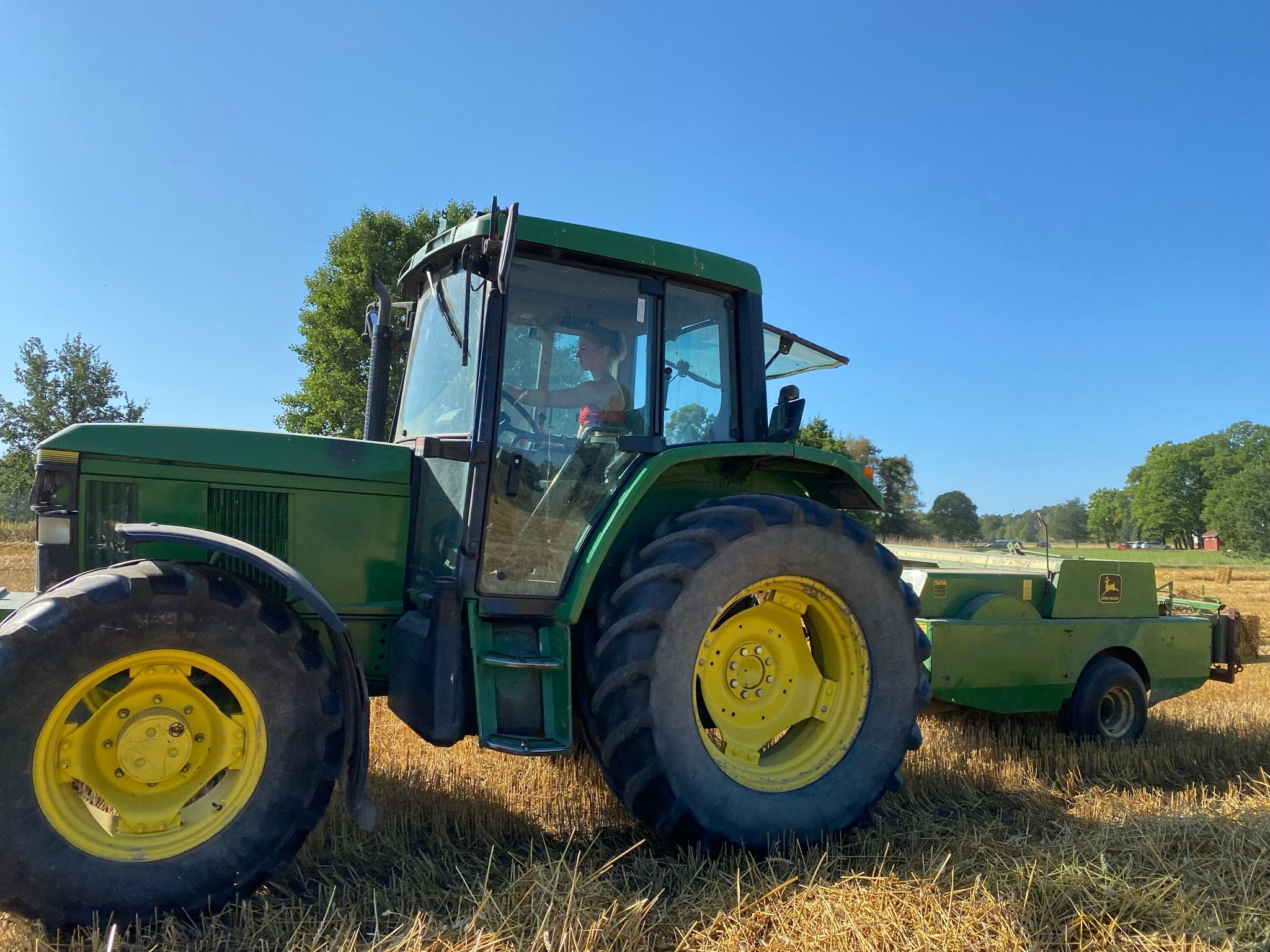 Elev kjører traktor med halmpresse.