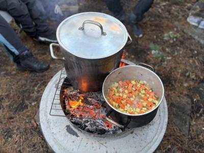 Mat tilberedes i kjeler på bålet.