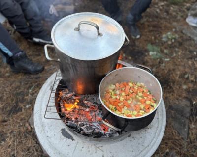 Mat tilberedes i kjeler på bålet.