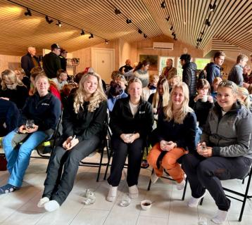 Elever som sitter i et foredragsrom.