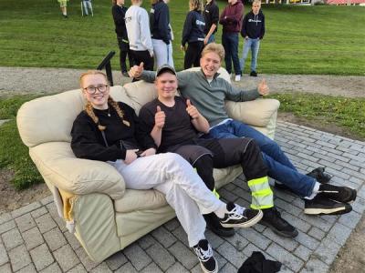 3 elever sitter i en sofa i parken