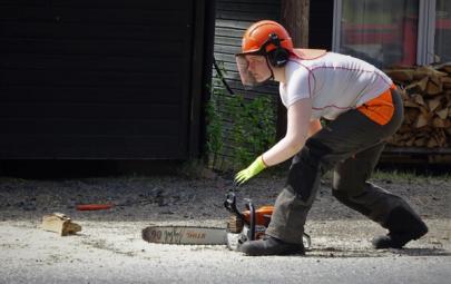 Konsentrert elev i verneutstyr og med motorsag