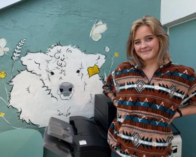 Elev står foran en veggillustrasjon.