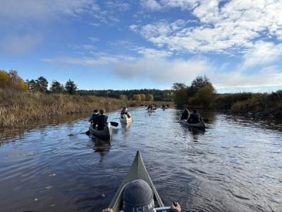 Elever padler i kano på en elv.