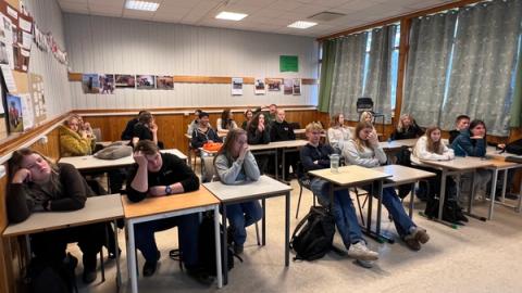 Elever sitter ved pultene sine i klasserommet